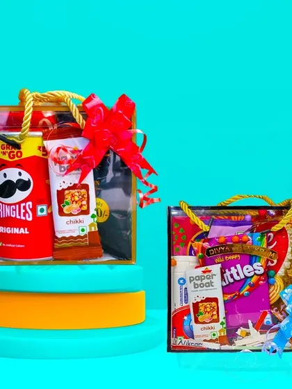 Here are two of our hamper sizes, showing the versatility of what you can create. The smaller bag is perfect for a few select items like Pringles and a drink, while the other shows a mix of snacks and candies. Both are finished with a festive bow.