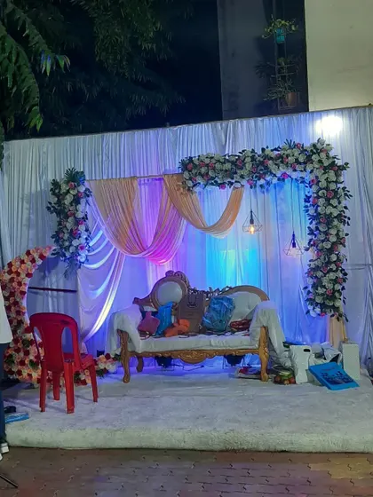 The engagement stage seen from the side, showing the depth of the floral arrangements and the effect of the blue and purple uplighting.