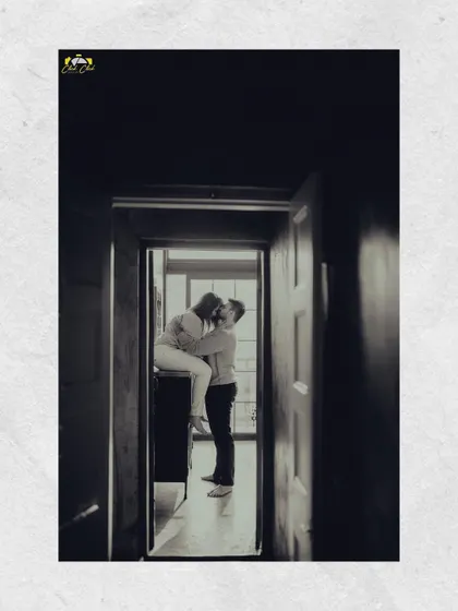 A black and white shot from a doorway, creating a beautiful, intimate frame for the couple's kiss. This image is from the same series as the creative dry ice shoot, showing variety within a single session.