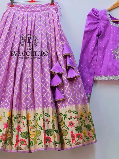 A long-sleeved lehenga in a lovely lavender color. The blouse has delicate embroidery, and the skirt has a traditional floral border.