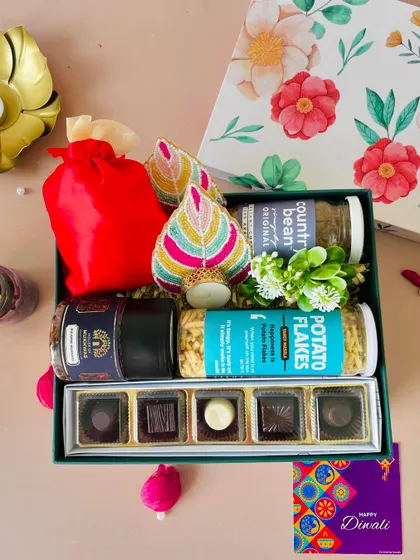 This floral lid box is packed with gourmet chocolates, snacks, coffee, and beaded t-light holders, offering a premium selection.