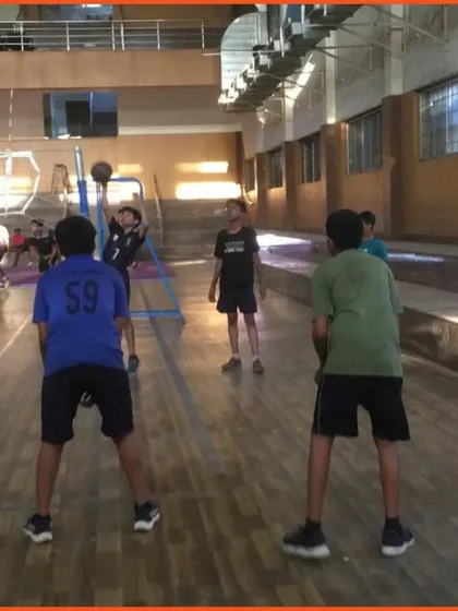 An athlete practices his spike approach using a stationary ball holder. This tool helps players focus purely on their vertical jump and arm swing mechanics without worrying about a moving set.