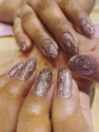 Shiny, shimmery, and perfect for the wedding season. This is a beautiful example of a rose gold cat-eye polish with a sparkling starburst design.