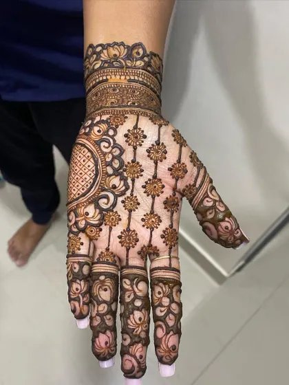 A beautiful design featuring a net of flowers covering the back of the hand, with a large circular motif on the wrist.