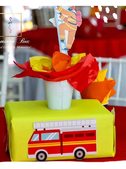 A close-up of a table centerpiece from the firefighter party, featuring a fire truck cutout and a paper 'flame' arrangement.