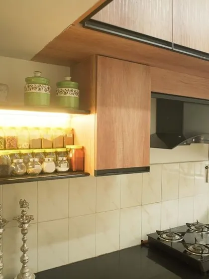 This image showcases the open shelving with integrated lighting, perfect for keeping everyday spices and plants. The warm wood tones and greenery create a welcoming and lived-in atmosphere.