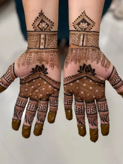 A lovely engagement mehendi with the couple's initials, M and R, inside a lotus motif. The design is simple, meaningful, and so pretty.