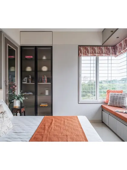 A closer look at the bed and window area. The glass-fronted display cabinet adds a touch of elegance and provides a space for personal treasures.