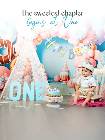 The sweetest chapter begins at one. This photo captures a quiet moment of reflection for the birthday boy, sitting thoughtfully amidst the festive decorations of his first birthday shoot.
