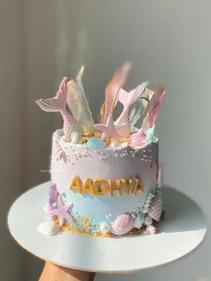 A magical mermaid theme cake that's perfect for an under-the-sea party. This 1kg Chocolate Truffle cake is decorated with shimmering mermaid tails, seashells, and pearls.