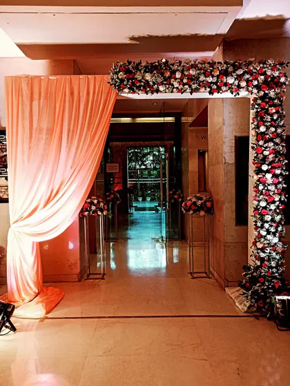 An elegant floral entrance arch for an indoor event, creating a warm and welcoming passage for guests.
