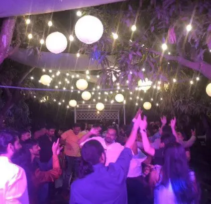 The party is lit by elegant paper lanterns and string lights, creating a beautiful ambiance.