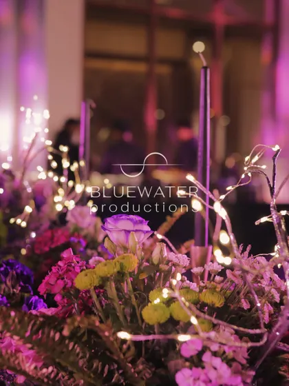A macro shot of a floral arrangement, with fairy lights twinkling among the purple and green blooms.
