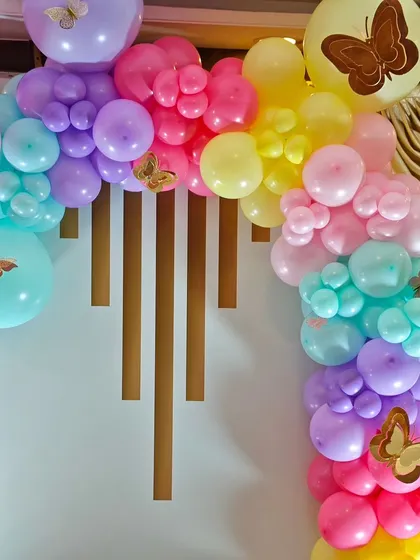 A detailed shot of a vibrant pastel balloon garland with delicate butterfly accents, showcasing a beautiful blend of colors for a cheerful party atmosphere.
