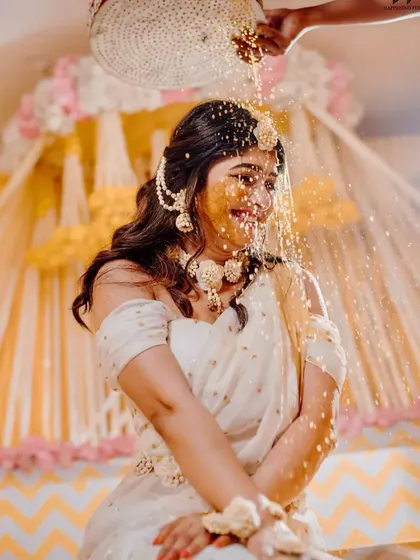 Capturing the pure joy of the Haldi ceremony. The bride is showered with flowers and turmeric, and my decor with its bright yellow drapes and floral accents creates a perfectly festive atmosphere.