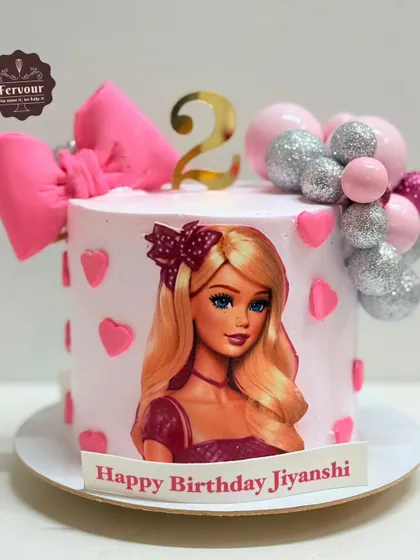 Another take on the Barbie theme, this cake for a 2nd birthday features a large edible image of Barbie, a fondant bow, and a cascade of pink and silver glittery balls.
