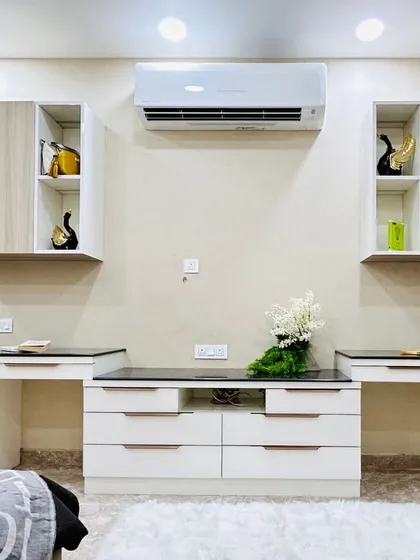 A practical and stylish bedroom designed for two kids. This image shows the dual study desks and overhead cabinets, ensuring each child has their own dedicated space for schoolwork.