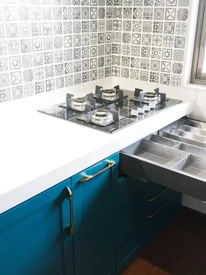 Organization is key next to the cooking area. This image shows a dedicated cutlery drawer with a stainless steel organizer insert, keeping spoons, forks, and knives neatly arranged and within easy reach.