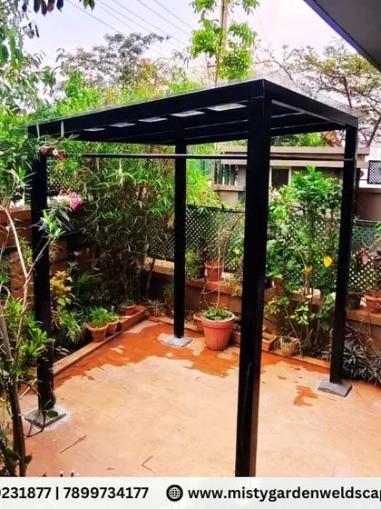 A modern and minimalist 3mm compact sheet pergola installed in a backyard in Chikkagubbi. This structure provides a perfect shaded retreat surrounded by lush greenery.