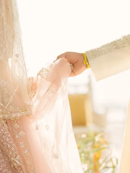 A close-up of the bride and groom's hands during the ceremony. This intimate shot focuses on the symbolic gesture of their union.