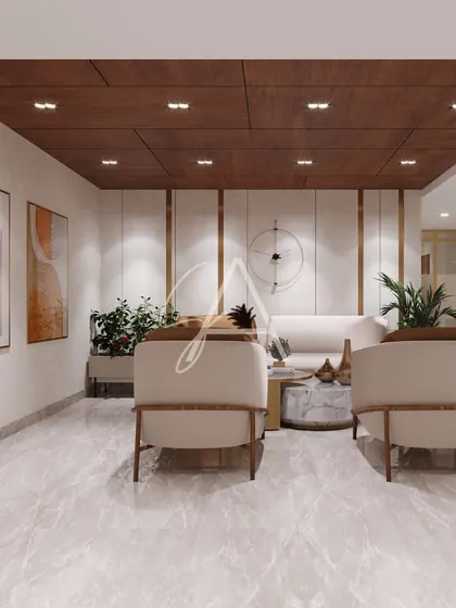 The visitors' lounge seen from the front. This angle highlights the marble coffee table and the warm, abstract art that complements the neutral tones of the furniture and flooring.
