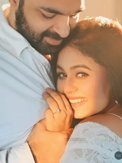 Sun-kissed and full of joy. This portrait uses natural light to create a beautiful flare, highlighting the bride's happy expression as she embraces her partner.