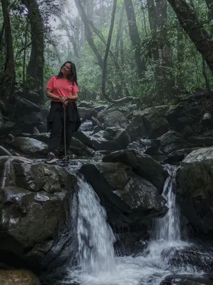 A beautiful shot of a trekker by a small waterfall on the Netravathi trail.