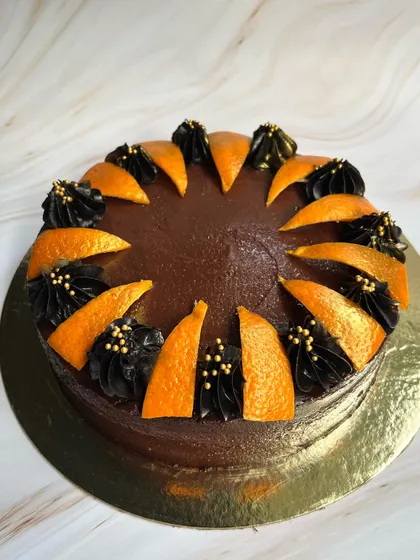 The beautiful contrast of dark chocolate frosting and bright orange slices makes this Drunken Zesty Belgian Chocolate cake a visual treat.