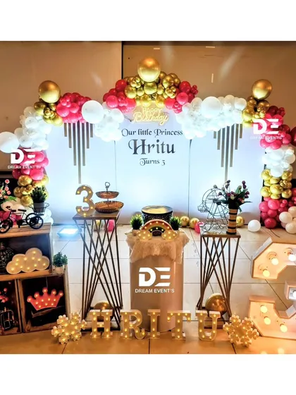 A full view of a princess-themed third birthday, featuring a custom backdrop, marquee letters, and a variety of charming props like a miniature bicycle and light-up clouds.