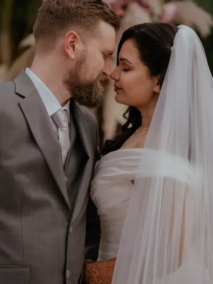 An intimate moment between the bride and groom, dressed in classic white wedding attire, after their beautiful Christian wedding ceremony.