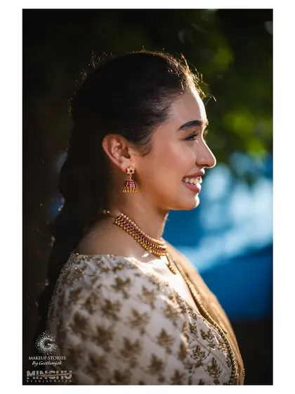 A side profile of Priyanka, highlighting her soft makeup and elegant hairstyle. This look is a perfect example of understated traditional beauty.