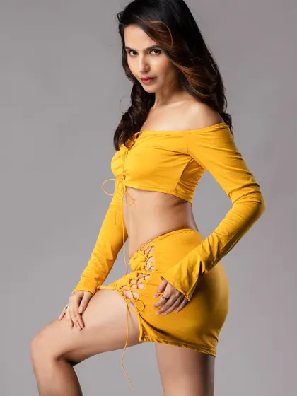 A side-profile shot of the model in the yellow outfit, showing her form and a confident pose.