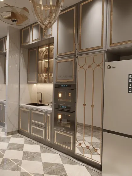 A closer look at the pantry and appliance wall in our grey and gold classical kitchen. The design features glass-front cabinets with intricate gold detailing and integrated double ovens.