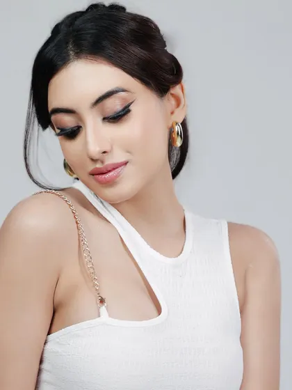 A soft and elegant beauty shot in a white dress against a clean background. This style is perfect for showcasing a model's classic beauty and is ideal for cosmetic or bridal brands.