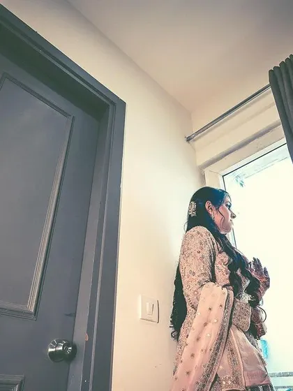 A pensive portrait of the bride looking out a window before her ring ceremony. These quiet, reflective moments are a beautiful part of the wedding story.