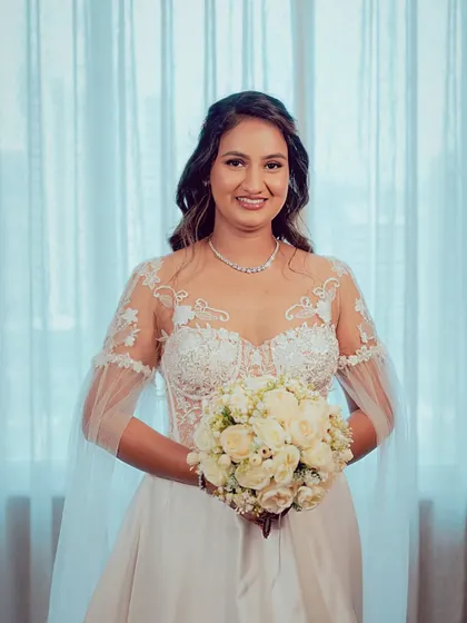 This bride is the picture of elegance. Her makeup is soft and natural, and her hair is styled in beautiful, flowing waves, complemented by a delicate hair accessory.
