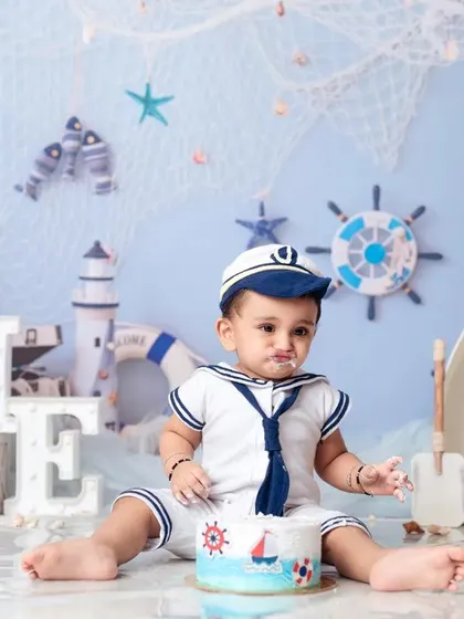 A messy but happy sailor after a successful cake smash adventure on the high seas.