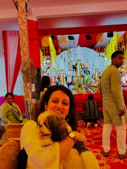 A smiling pet parent cuddles her Shih Tzu while sitting at the event. These are the heartwarming moments of connection that our pet-friendly festivals are all about.