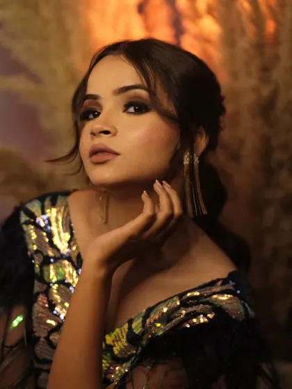 A graceful pose with a hand delicately placed by her chin. This portrait highlights the model's elegant features and the glamorous makeup.