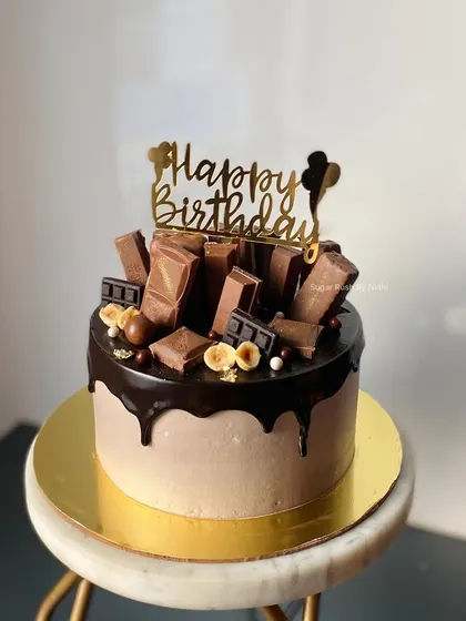 A close-up of the Chocolate Overload cake, showing off the glossy couverture chocolate drip and the generous toppings. It's a 750g cake packed with flavor.