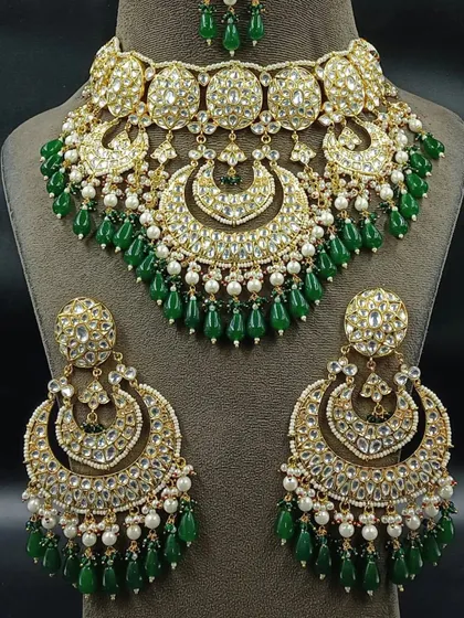 A stunning Pakistani-style bridal choker with large chandbali earrings. The intricate design with green beads and pearls makes this a standout rental piece.