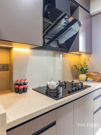 This modern galley kitchen is a great example of functional elegance. Sleek, handleless cabinetry in a warm neutral tone, under-cabinet lighting, and a glass door for natural light make the narrow space feel open and bright.