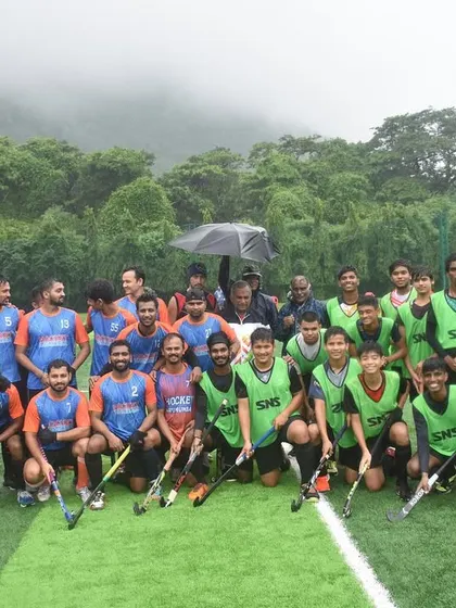 Both teams pose together after a hard-fought match, demonstrating the spirit of sportsmanship that is central to the game of hockey.