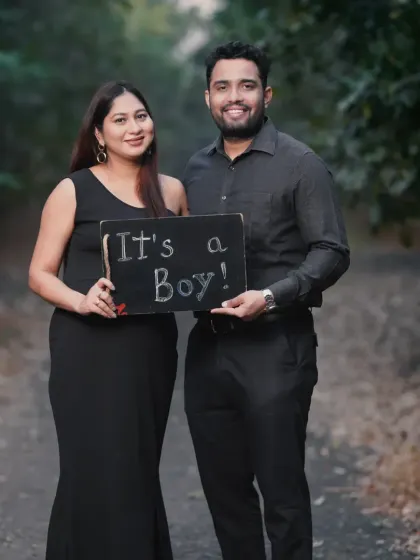 An expecting couple holding a sign that says "It's a Boy!". This is a wonderful way to combine a pregnancy announcement with your maternity photoshoot in a natural, outdoor setting.