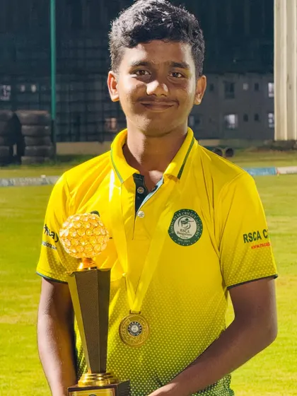 A young champion from our boys' team proudly holds his trophy.