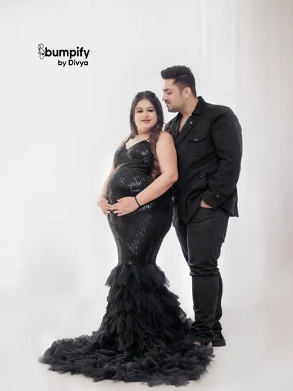 A bold and glamorous studio maternity look. This couple chose matching black outfits, with the mom to be shining in a sequined gown for a truly elegant portrait.