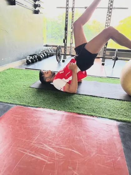 A client performs a single-leg glute bridge, an excellent corrective exercise to activate the glutes and improve pelvic stability.