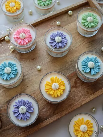 The custom Daisy jar candles, arranged on a wooden tray before being packaged. They look like a beautiful pastel garden.