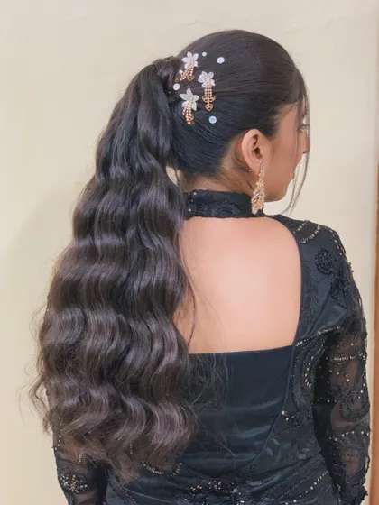 A high, bouncy ponytail with retro waves. The look is finished with delicate floral accessories for a touch of glam.
