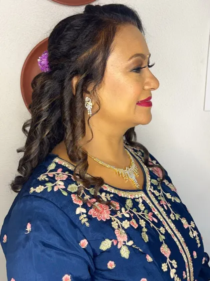 A side profile showing the soft curls and braided detail in her hair.